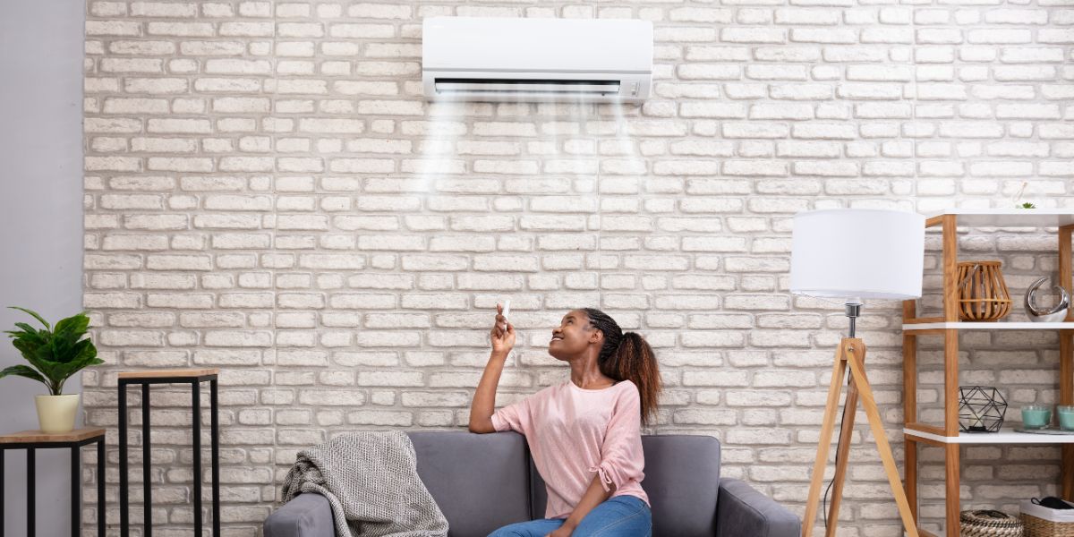 Benefits Of Zoning Systems For Heating And Cooling 1 Woman Operating Air Conditioner - Benefits Of Zoning Systems For Heating And Cooling